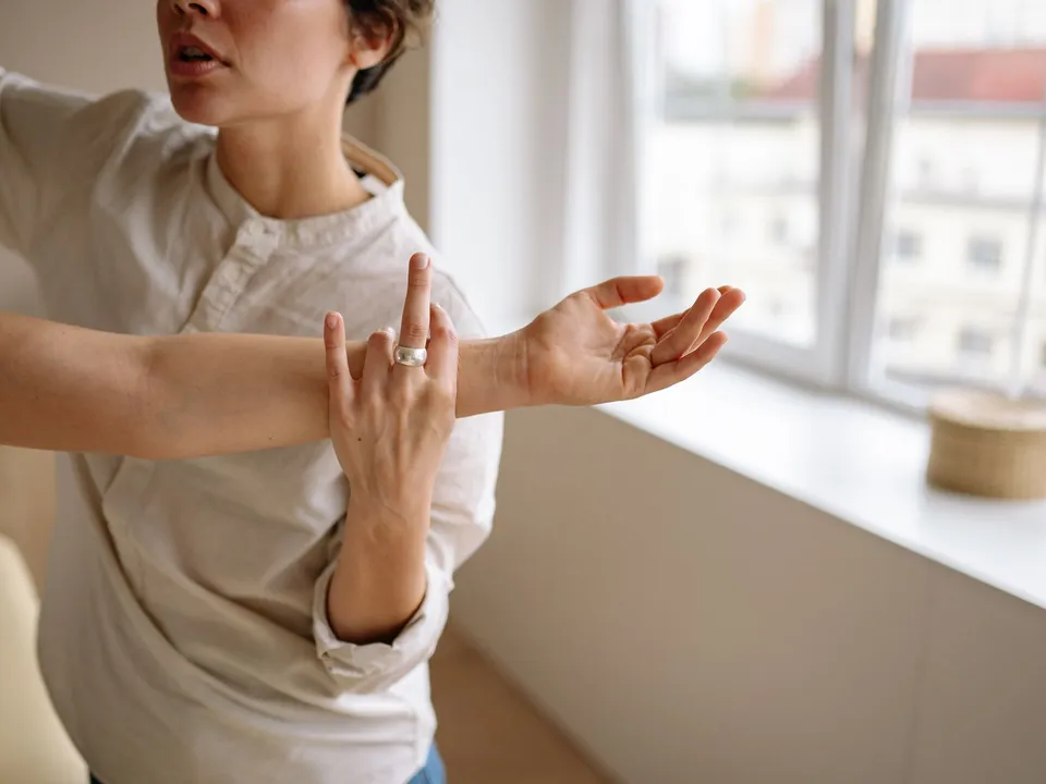 A therapist holds a patient’s arm out straight during a stretch.